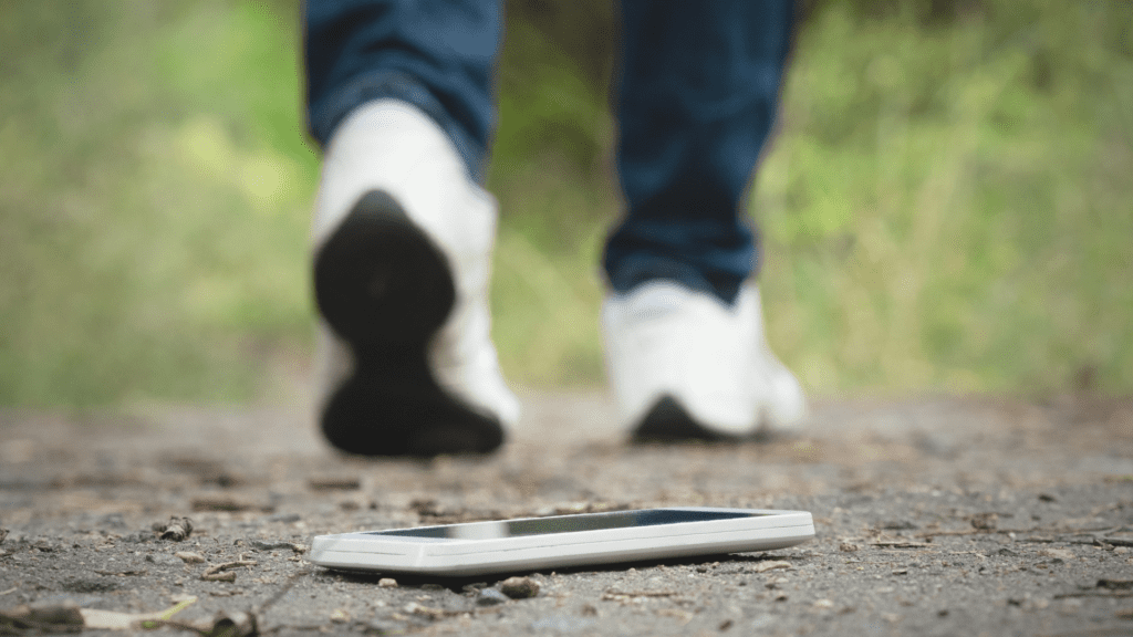 man walking in park and losing phone