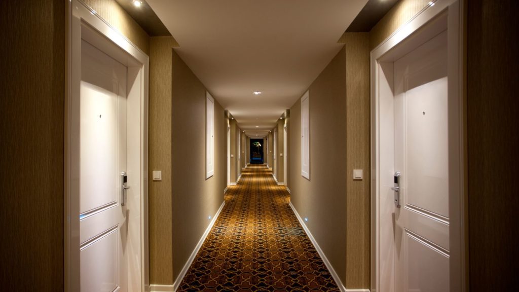 A hotel hallway where the guests are using security products for hotel stays